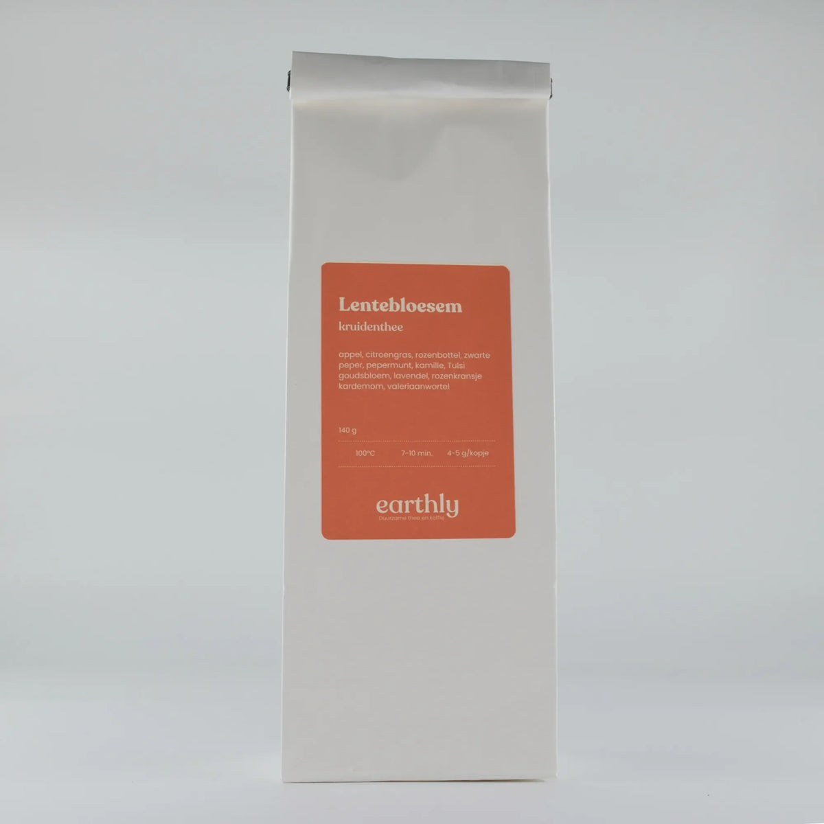 Witte zak met oranje label Lentebloesem kruidenthee van Earthly met ingrediënten en zetinstructies