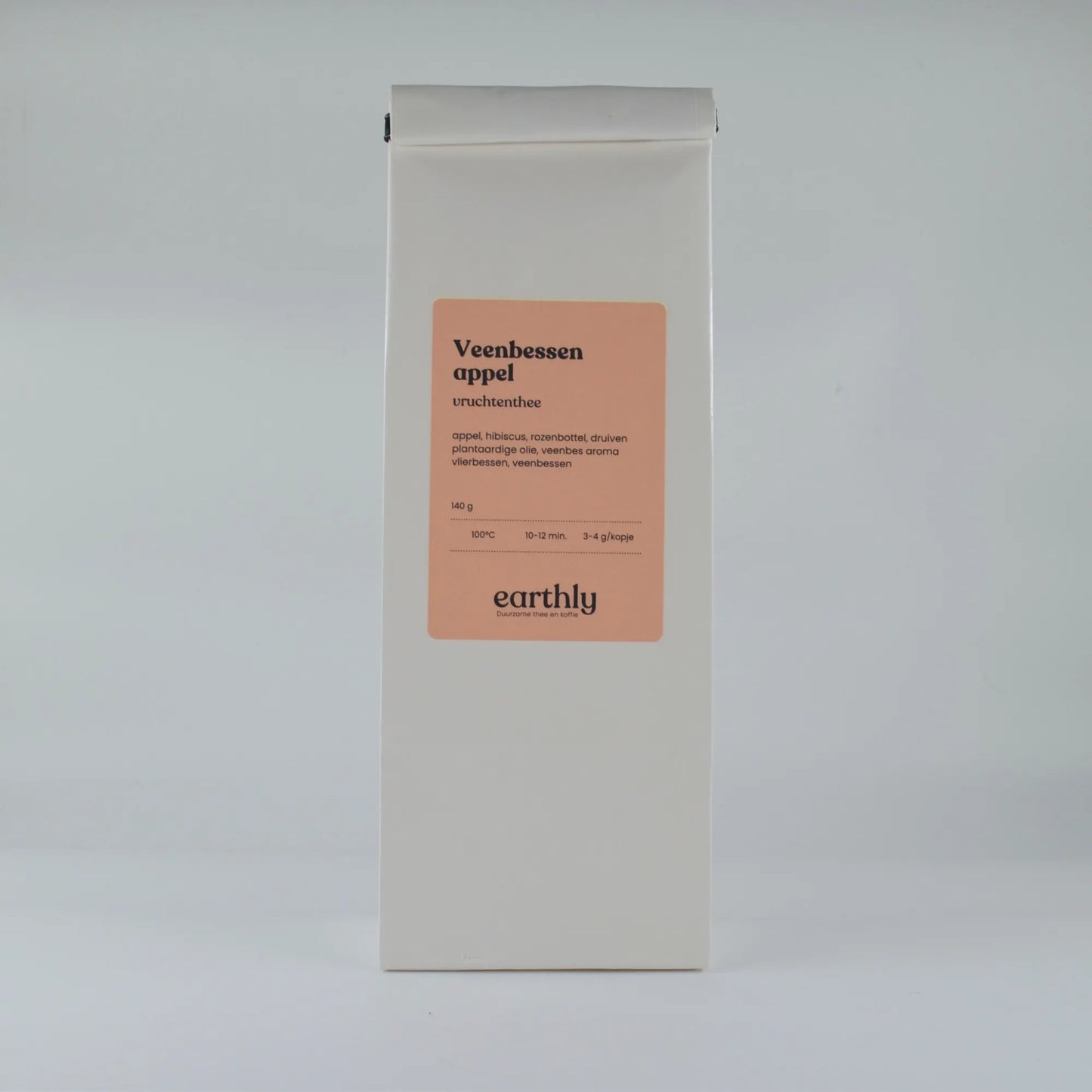 Wit pakje Veenbessen appel vruchtenthee met oranje etiket van Earthly op neutrale achtergrond