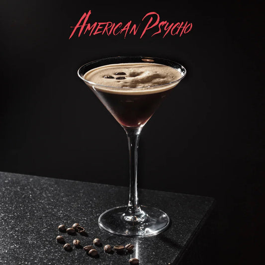 Cocktail American Psycho in martiniglas met koffiekorrels op zwarte marmeren tafel en donkere achtergrond