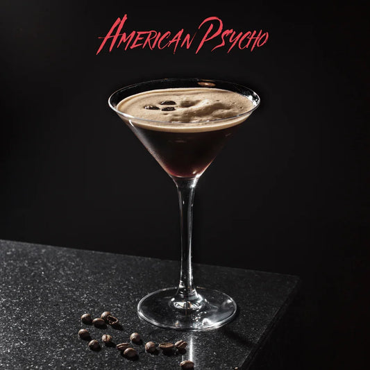 Cocktail American Psycho in martiniglas met koffiekorrels op zwarte marmeren tafel en donkere achtergrond