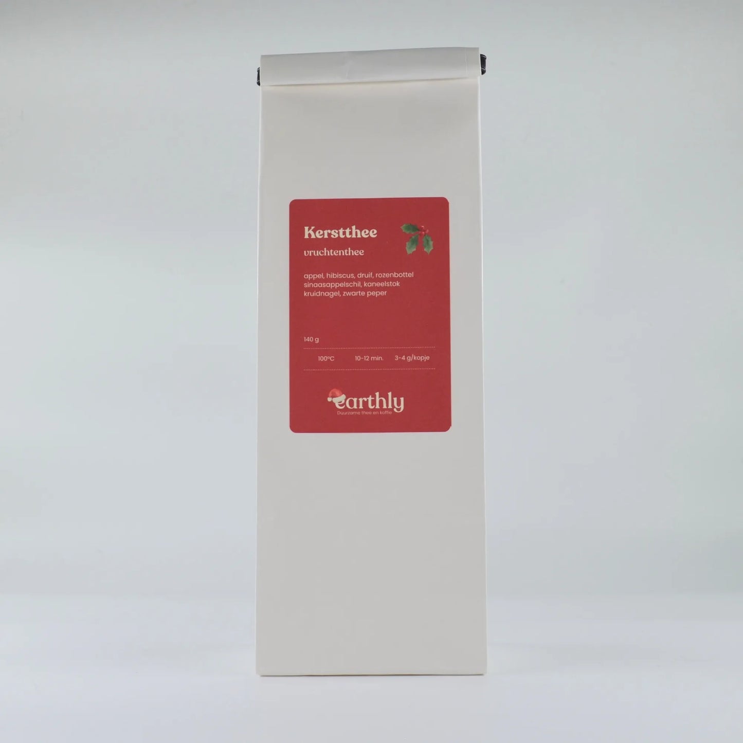 Witte verpakking met rode etiket van Earthly kerstthee vruchtenthee, ingrediëntenlijst en zetinstructies