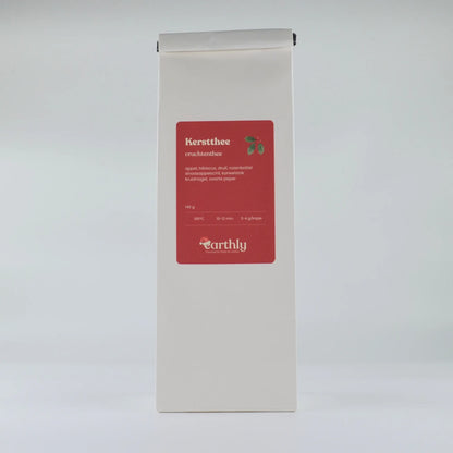 Witte verpakking met rode etiket van Earthly kerstthee vruchtenthee, ingrediëntenlijst en zetinstructies
