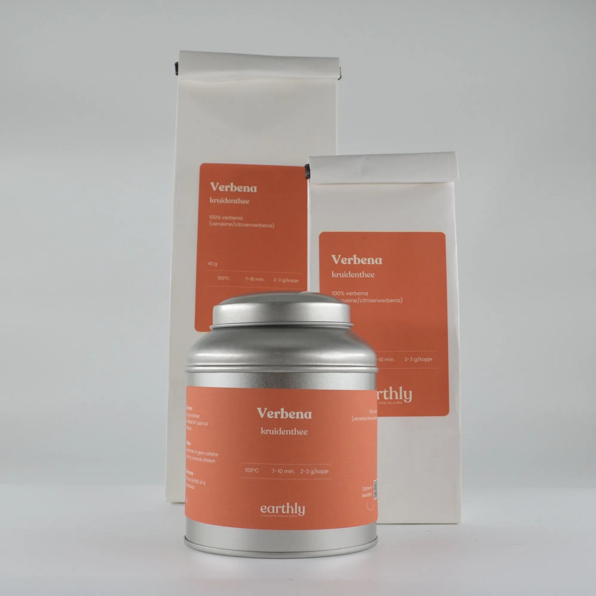 Verbena kruidenthee verpakkingen met oranje etiketten en zilveren theeblik, natuurlijke kruidenthee