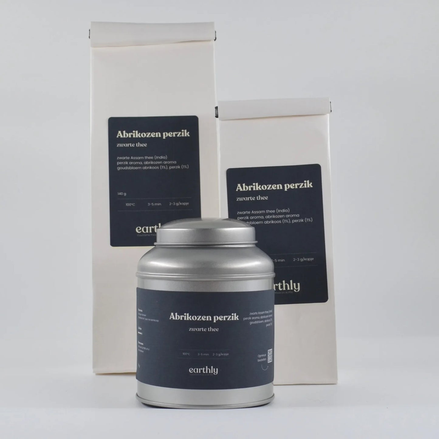 Abrikozen perzik zwarte thee verpakkingen en metalen theebus van Earthly