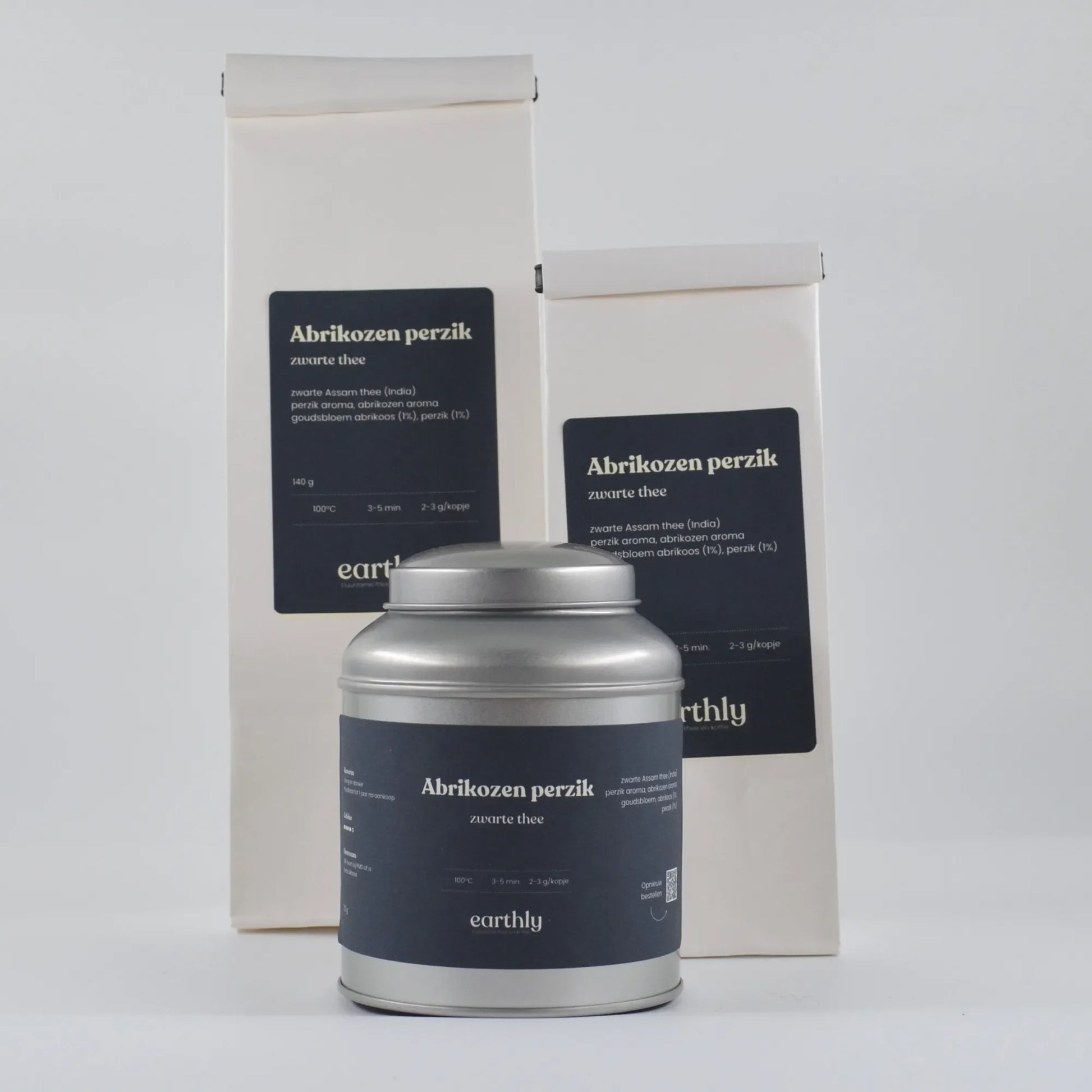 Abrikozen perzik zwarte thee verpakkingen en metalen theebus van Earthly