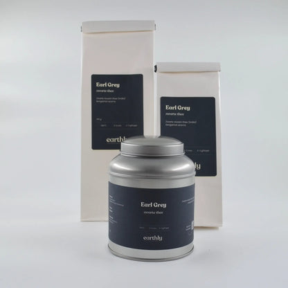 Earthly Earl Grey zwarte thee in metalen blik en twee witte verpakkingen met zwarte labels