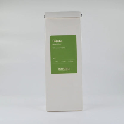 Witte verpakking met groene label voor Hojicha Japanse groene thee van Earthly, 140g