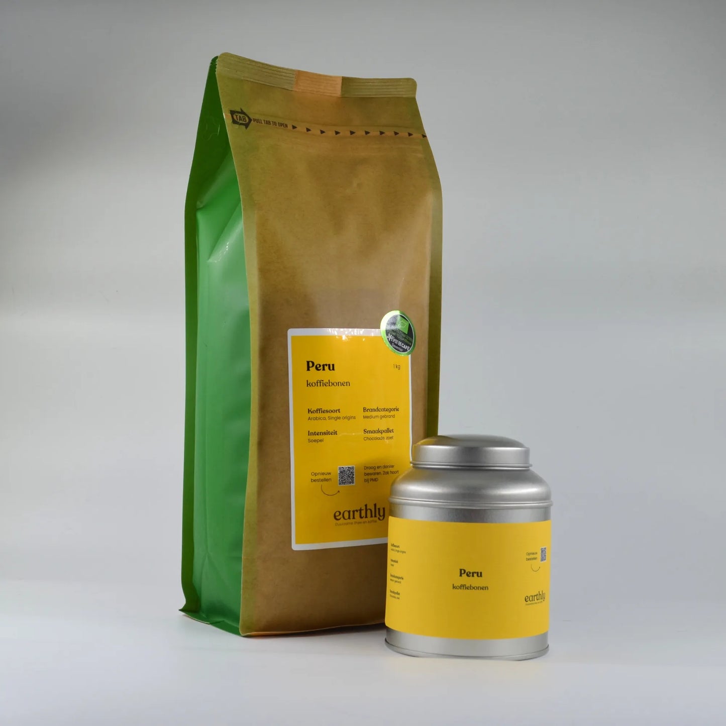Peru koffiebonen in groene papieren zak en zilveren blik met geel etiket op witte achtergrond