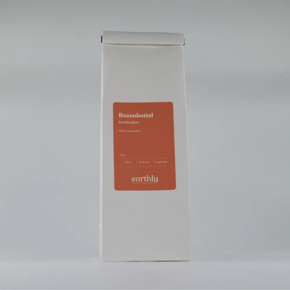 Witte verpakking met oranje label van Earthly Rozenbottel kruidenthee, 140 g